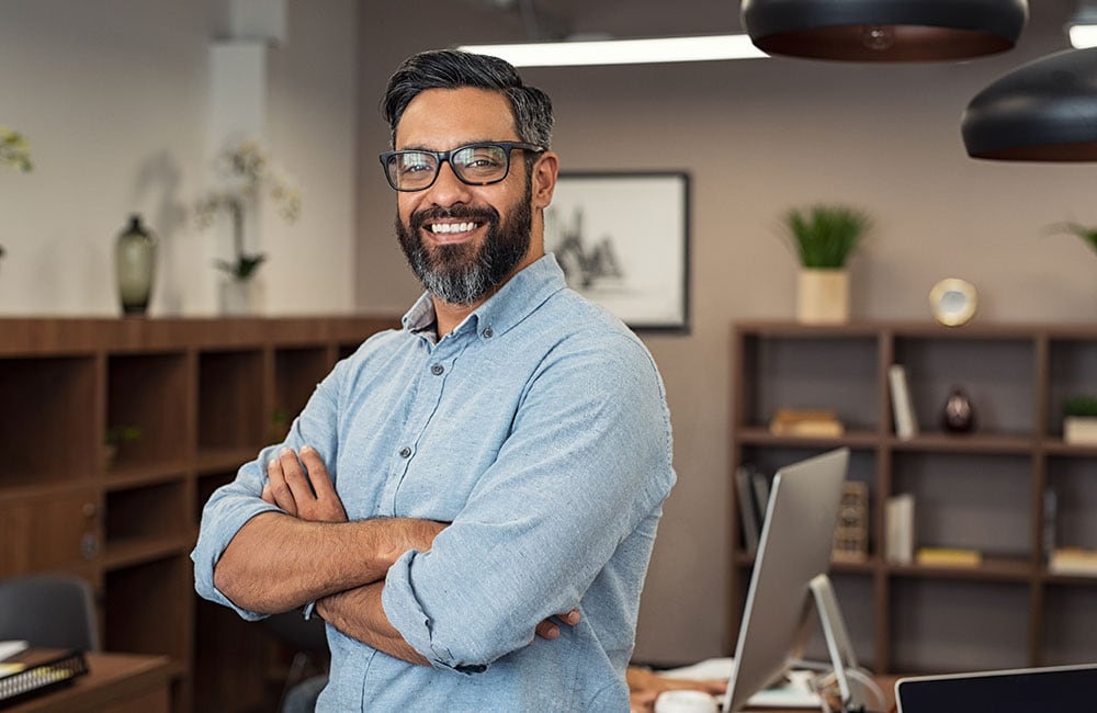 Business man big smile in front of a desk